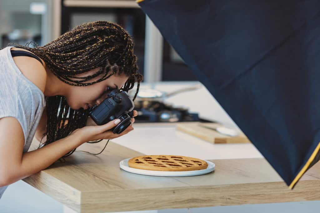 joven sacando foto a un pastel simulando a creador de contenido de recetas