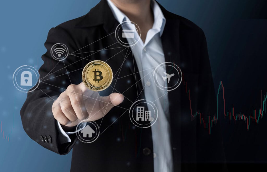 hombre señalando con la mano moneda bitcoin haciendo alucion al nicho de criptomonedas