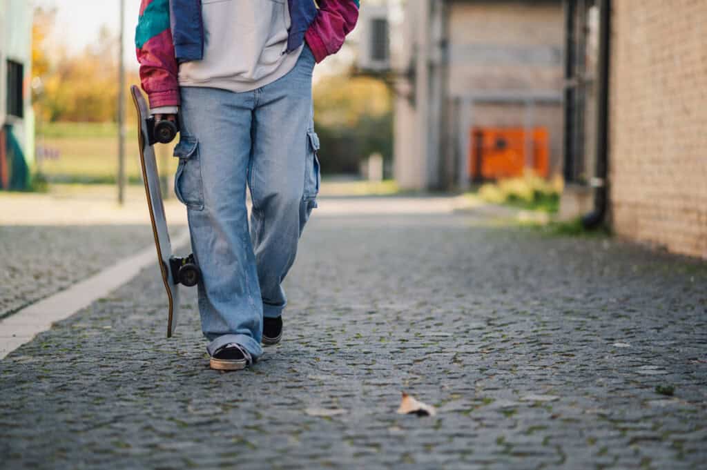 joven caminando con skate en mano