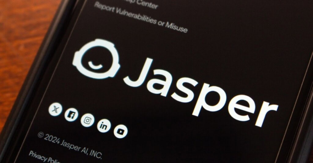 Pantalla de un teléfono móvil mostrando el logo de Jasper AI, herramienta líder en generación de contenido con inteligencia artificial.